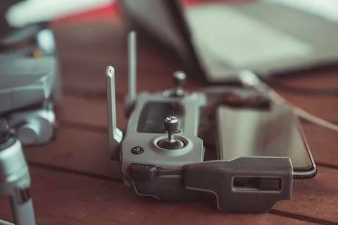 Drone quadcopter with a flight controller and notebook on the old wooden table. Stock Photos