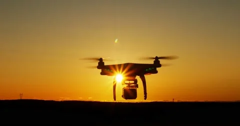 Drone quadcopter hovering taking aerial footage at sunset Stock Footage 67219595