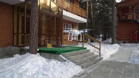 Drone, quadrocopter soars against the backdrop of the cottage next to the forest Stock Footage 85672250