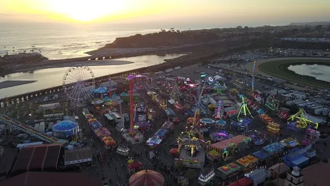 Drone quickly fly over fair carnival rides and midway amusements at sunset 库存影片 98267892