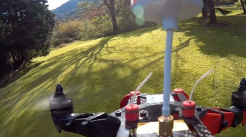 Drone racing quad copter flying FPV through trees in park Stock Footage 66859257