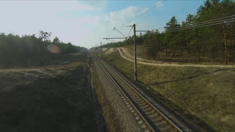 Drone racing view. Fly over railways in forest at sunset. Dynamic shot Video stock 106523394