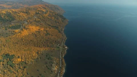 Drone Railroad two paths along lake Baikal autumn yellow forest train rides Shot Video stock 142778199
