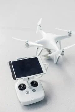 Drone with a remote control and a tablet on it on a gray concrete background. Stock Photos