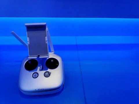 Drone remote control device with blue light on shelf and copy space on right. Stock Photos