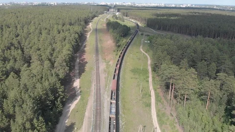 A drone removes a passing freight train through a coniferous forest. Stock Footage 118874599