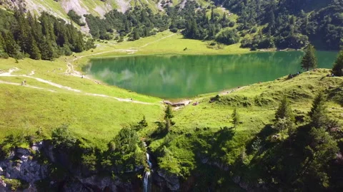 Drone Retreat from Waterfall Flowing from Unterer Gaisalpsee Stock Footage 283080183