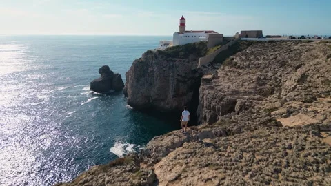 Drone Reveal of Cabo de São Vicente, with a young man admiring the view Stock Footage 257066484