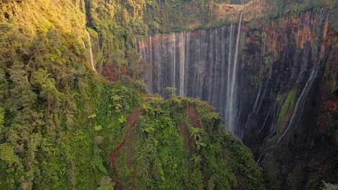 Drone Reveal Flight Over Hill Uncovering Tumpak Sewu Waterfall East Java Video stock 334647476