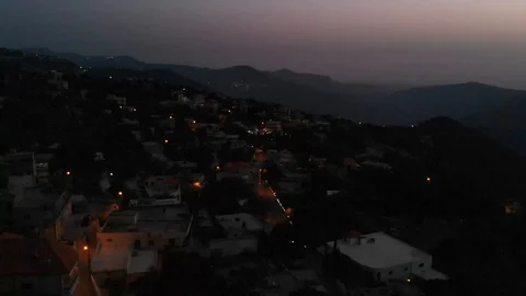 Drone reveal of middle eastern city behind mountain range at night Stock Footage