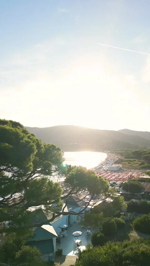 Drone Reveal Shot from Trees Over Lacona Beach with Colorful Umbrellas  Spi.. Vídeo Stock 334939326