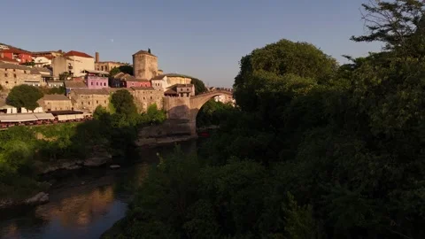 Drone Reveal of Stari Most Bridge and Riverfront Cafes in Mostar Sunset 4K Stock Footage 337831259