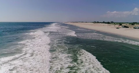 Drone reverse flyby Gilgo Beach surfers Stock Footage 116613776