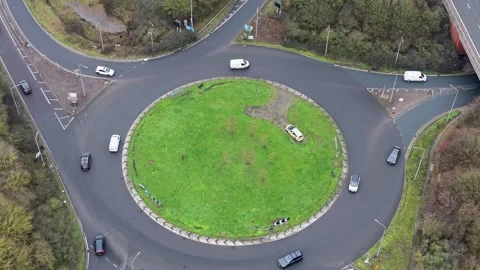 Drone reverse by Waltham Abbey roundabout with traffic and Highways Agency car. Stock Footage 328389700