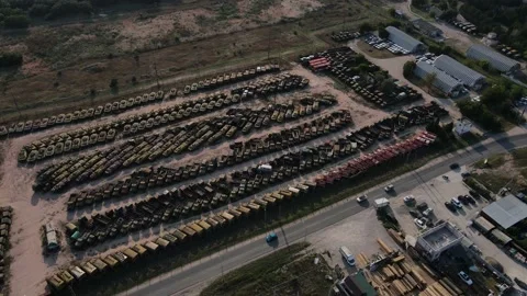 Drone revolves around a graveyard of heavy equipment and cars Stock Footage 161618149