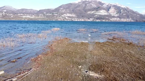Drone Rises Above The Alpine Lake water after a snowfall Stock Footage 166802794
