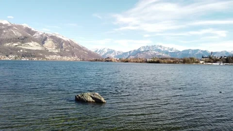 Drone Rises Above The Alpine Lake Pusiano after a snowfall Stock Footage 166802890