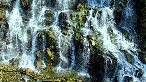 The drone rises above a beautiful waterfall Stock Footage 140743513