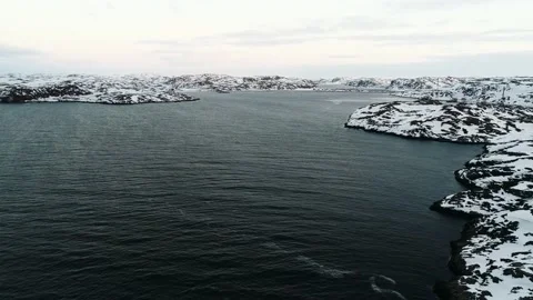 The drone rises above the dark waters of the Arctic Ocean near the rocky shore Stock Footage 169464499