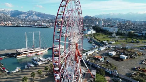 The drone rises above the Ferris wheel against the backdrop of the city Stock Footage 256158472