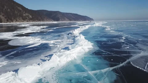 Drone rises above the frozen crystal ice of the lake Baikal. Top view. Stock Footage