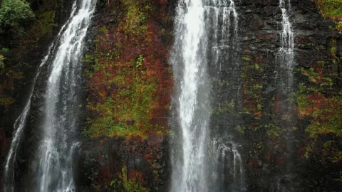 Drone rises above a high waterfall on a cliff at Opaekaa Falls, Kauai, Hawaii Video stock 136418253