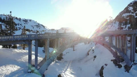 Drone Rises Above Highway 40 Bridge with Sun Flare in Winter Snow Stock Footage 148025875