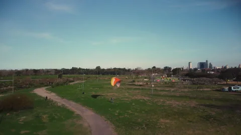 A drone rises above the park, a flock of birds flies past, paragliding 스톡 동영상 252171927