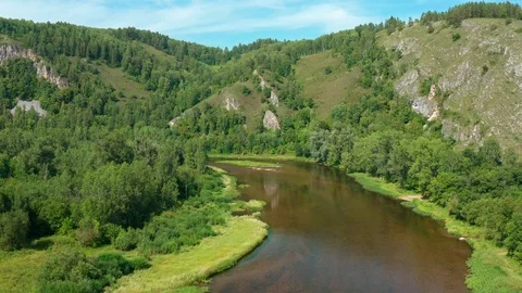 A drone rises above the river overlooking a beautiful mountain range. Vidéo 116601763