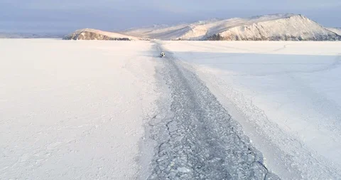 Drone Rises Above Trail Left by a Boat on the Ice of a Frozen Lake. Winter Video stock 123765600