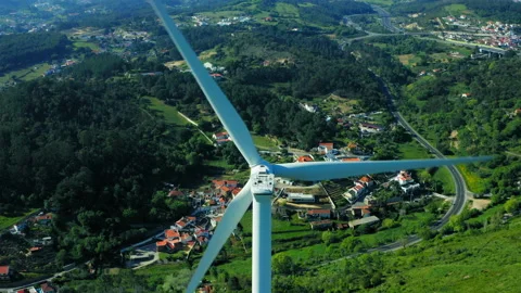 Drone rises in front of a wind turbine generating electricity against the b.. Stock Footage 239579237