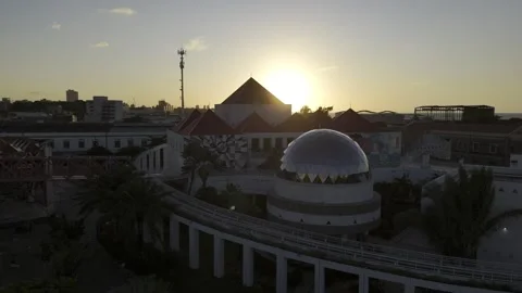 Drone rises up from ground in front of dome at Dragão do Mar to reveal sunset Stock Footage 282664376
