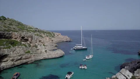 A drone rises over a bay in Mallorca with boats and shows the skyline. Stock Footage 221739489