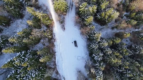 Drone rises over car on snowy forest road in Parc naturel régional du 動画素材 335923705