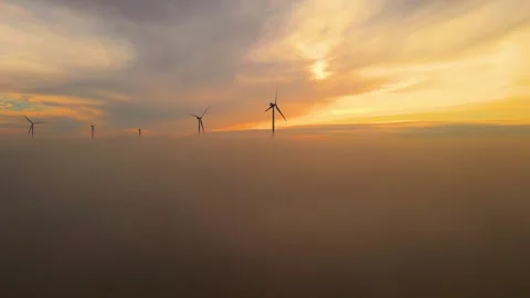 Drone rises over clouds of morning fog. Windmills farm with stopped wind Stock Footage 265063591
