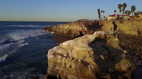 Drone rises over ocean and cliffs during golden hour Stock Footage 71132680