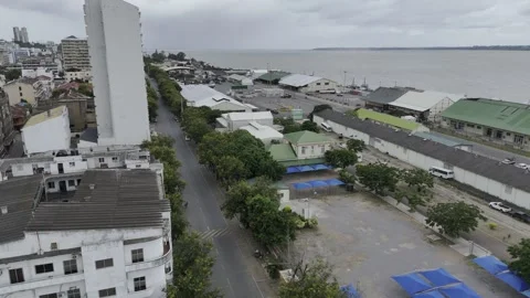 Drone rises up over parking lot with blue tarps, next to Mbuluzi River Stock-Footage 333841976