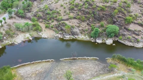Drone Rises Over Pond and Rocky Hillside in Rural Rajasthan Stock Footage 312364652