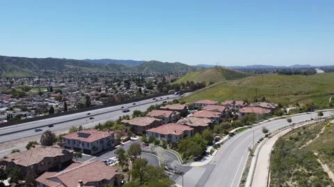 Drone rises over Simi Valley, Mountains, Highway, and Homes Stock Footage 271669300