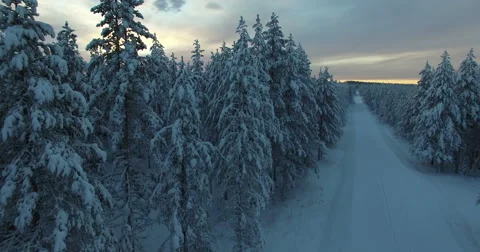 Drone Rises Slowly From Frozen Path Across Endless White Forests Into The Sunset Stock Footage 61142457