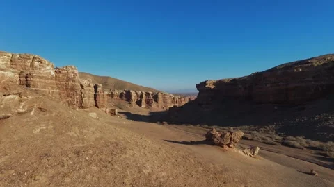A drone rises smoothly from the bottom of the Charyn Canyon, revealing its .. Stock Footage 325960809