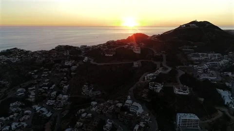 Drone Rises Toward a Sunset Behind Pedregal's Residential Hills in Cabo San Stock Footage 342033469