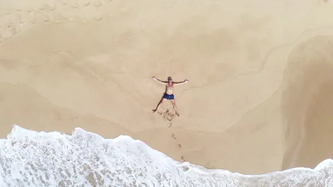 Drone Rising Above Man Lying on Sandy Tropical Beach Stock-Footage 344418130