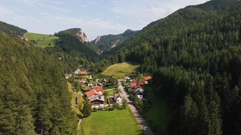Drone Rising Above Small Alpine Village at the Foot of the Mountains Stock Footage 323607677