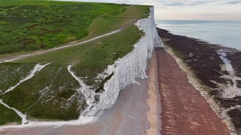 Drone rising above white cliffs and calm ocean on a peaceful scenic beach Stock Footage 309763876