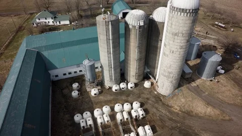 Drone rising angled view of quebec dairy farm silos in spring Stock Footage 93363066