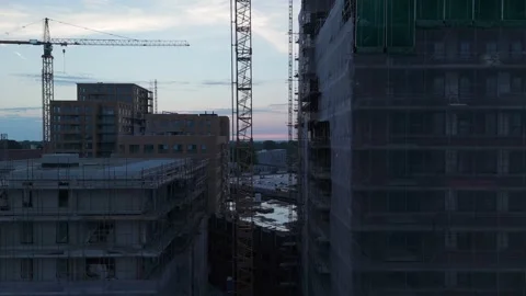 Drone rising between new construction buildings at dusk Stock Footage 345255563