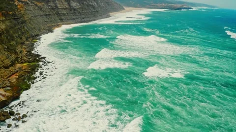 Drone is rising camera  over blue Atlantic ocean, rocky coastline. Stock Footage 306636094
