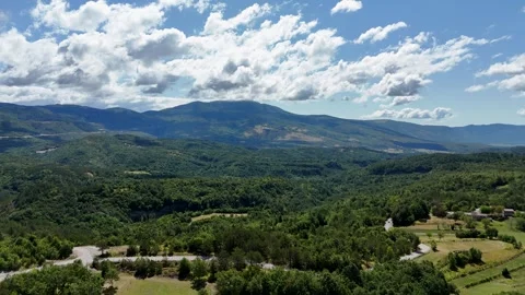 Drone rising over lush green mountain valley and distant ridge Stock Footage 323504239
