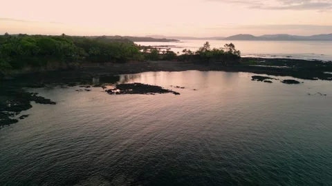 Drone rising over pacific ocean during sunset with slight tilt down Stock Footage 262662213